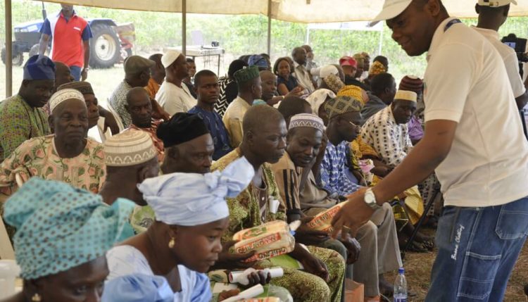 Picture of Gregory Nwaoliwe, HQCF Project staff, gives 10% HQCF-Wheat bread to participants during the field day.