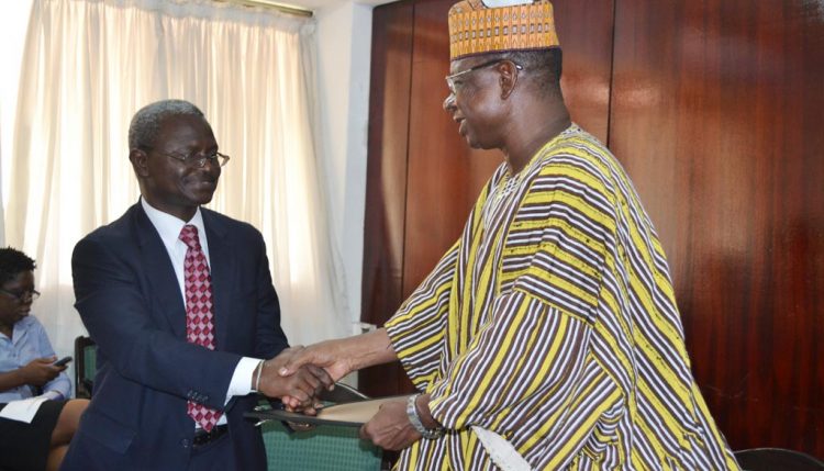 Photo of IITA’s Asamoah Larbi and the Deputy Minister of Environment, Science and Technology Information, Dr Alfred Tia Sugri, shake hands after the signing.