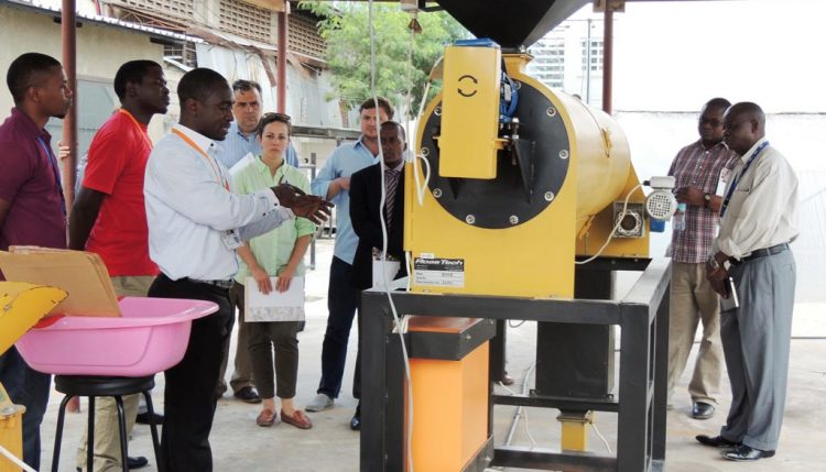 Picture of IITA staff demonstrate to the visiting team the production of AflasafeTZ at IITA-EA hub in Tanzania.