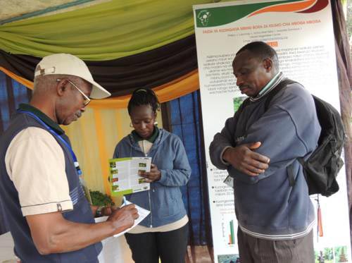 Picture of Festo Ngulu, Africa RISING Babati coordinator noting down information given by Paskali, a farmer from Mananga village-Babati