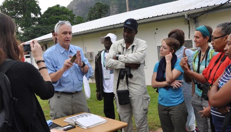 Picture of Tom Smith, Professor of Evolutionary Biology, UCLA, talks to visitors about bird diversity.