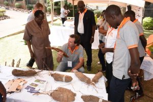 Picture of Piet VanAsten explaining to Mr John Mitala the cassava breeding process as he inspects the crop breeding booth.