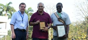 Picture of Bruce Coulman congratulates Atehnkeng on his award, with Ranajit Bandyopadhyay, leader of the Aflasafe team, looking on.