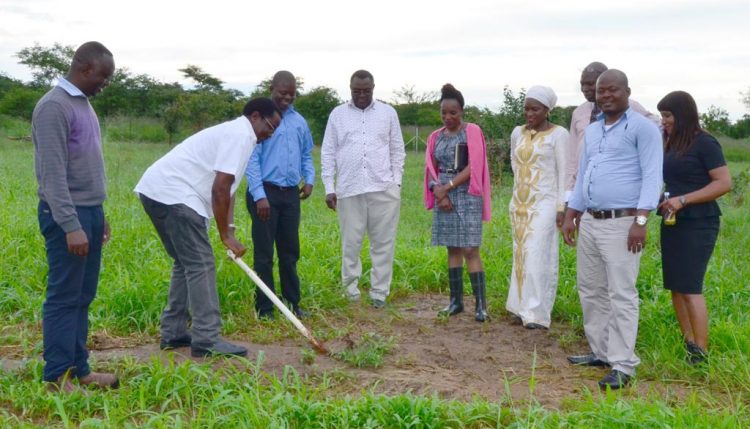 Picture of Chikoye breaking ground at the future site of the maize seed storage and warehouse facility at SARAH campus as IITA staff and construction representatives look on.