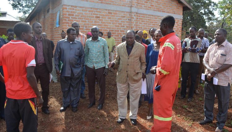 Picture of The regional commissioner (wearing cream colored pants) visiting project partners in Tanzania.