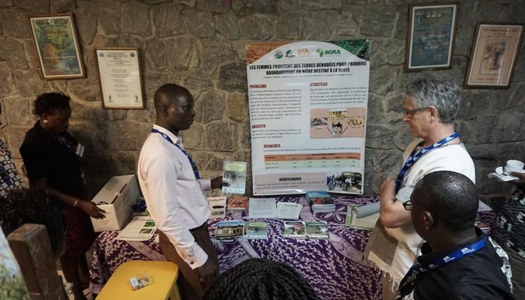Picture of Kayode Are explaining the information products produced by IAR&T at the display of materials produced by the various partners during the project.