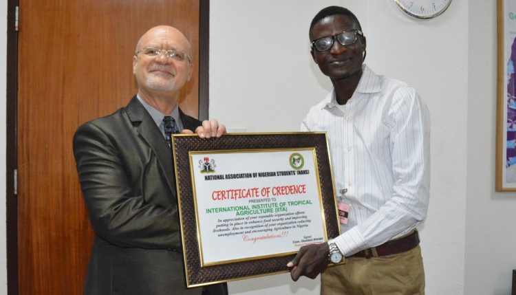 Picture of Afolabi presenting a certificate of credence to IITA on behalf of all Nigerian undergraduates.