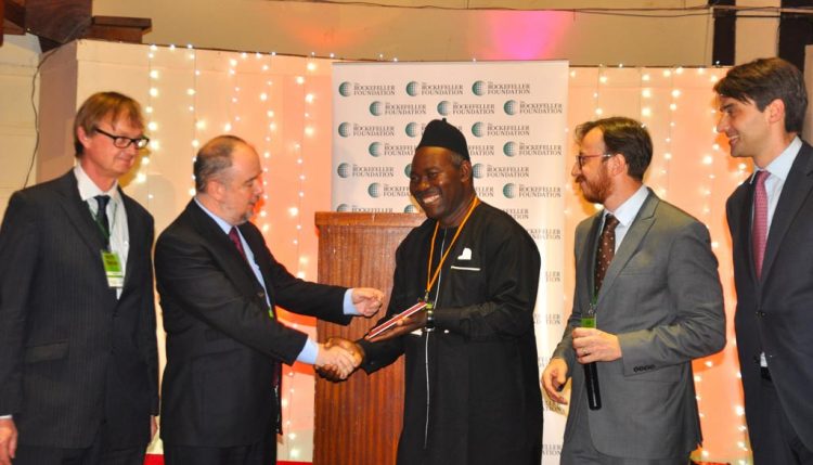 Picture of Okechukwu and Dalberg and Ford Foundation representatives giving award plaque to winner of the challenge from NRI