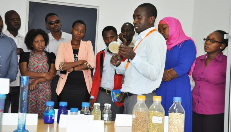 Picture of Jacob Njegela, Research Associate at IITA, explains how aflasafe was developed and manufactured in the lab at IITA East Africa hub.