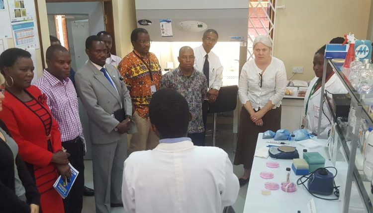 Picture of Jocelyn Brown (second from right) listens to a technician’s briefing during the lab visit.