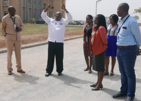 Picture of DG Sanginga (with raised arms) and staff at the Abuja Station on one of the newly constructed roads.