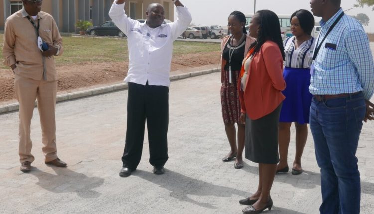 Picture of DG Sanginga (with raised arms) and staff at the Abuja Station on one of the newly constructed roads.