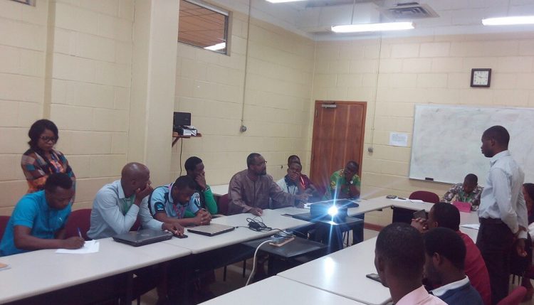 Picture of Afolabi Sanni (standing) fielding questions from other participants.