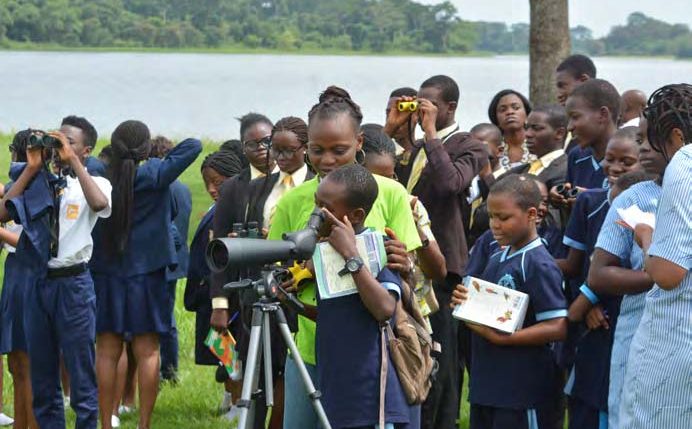 Picture of Students using binoculars to watch migratory birds during the bird watching session at IITA lake side