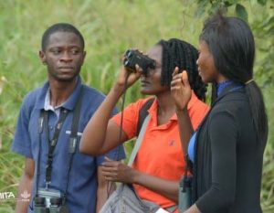 Picture of some participants practicing the bird watching exercise using binoculars at the forest area of IITA