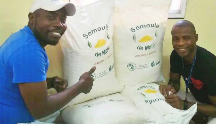 Picture of Two COPAKIN agripreneurs showcasing 25-kg bags of high quality semolina.