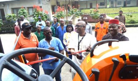 Picture of Gbassey Tarawali cutting the ribbon as staff members look on