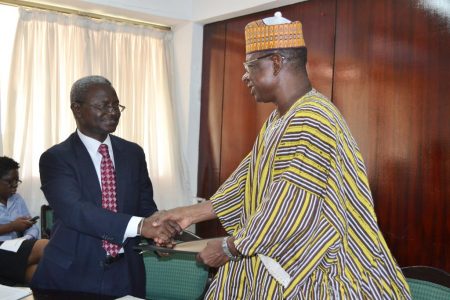 Photo of IITA’s Asamoah Larbi and the Deputy Minister of Environment, Science and Technology Information, Dr Alfred Tia Sugri, shake hands after the signing.