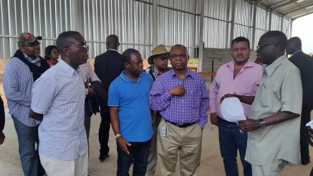 Picture of Chiji Ojukwu of AfDB (center) and H.E. Matata Ponyo (left) listen to IITA’s Nzola Mahungu (right), IITA Representative in DR Congo, talking about the cassava processing equipment introduced through the SARD-SC project funded by AfDB.