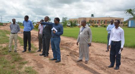 Picture of Chikoye explaining to Chief Kaputa (in a suit) about the different cassava varieties being tested at the IITA-SARAH campus.