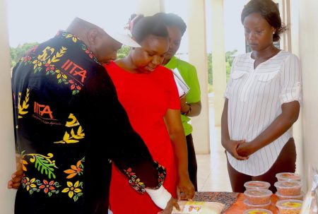 Picture of Youth Agripreneurs showcase some of their products to the DG (left)
